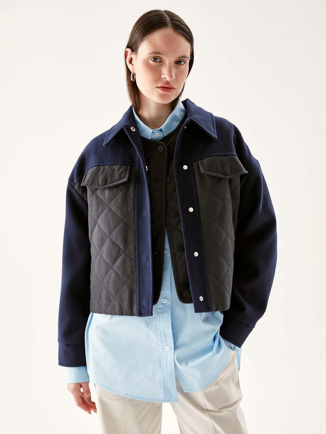 Persona con chaqueta acolchada y camisa formal.